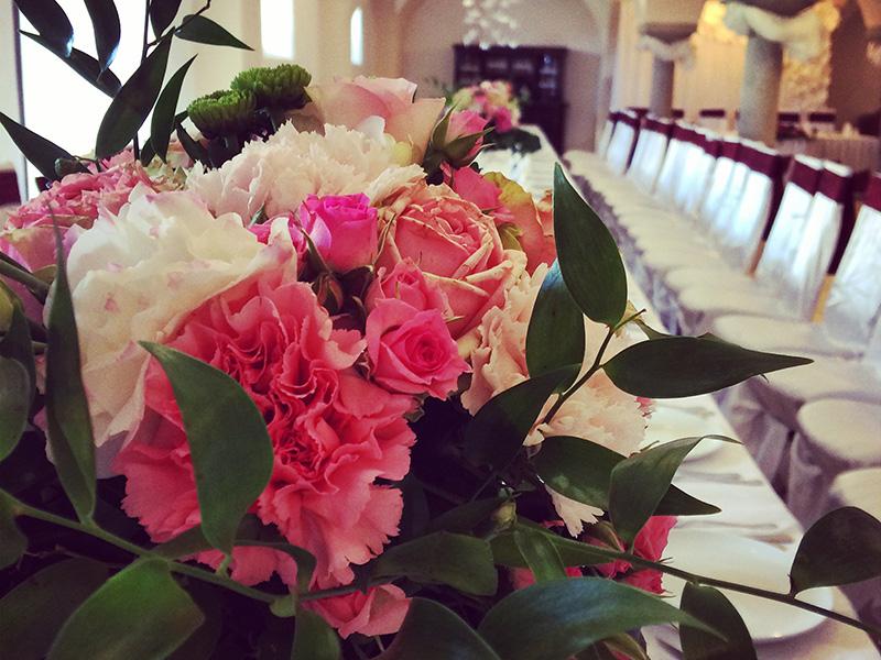 Strauß aus Rosen und Nelken auf der Hochzeitstafel