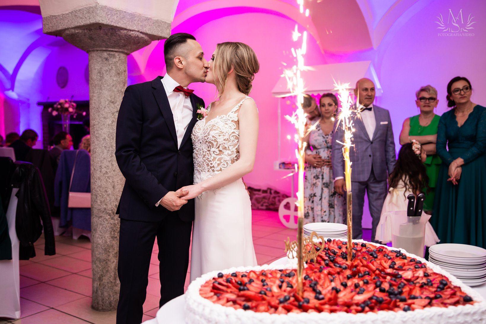 Brautpaar mit Torte und Wunderkerzen bei der Hochzeit im Schloss
