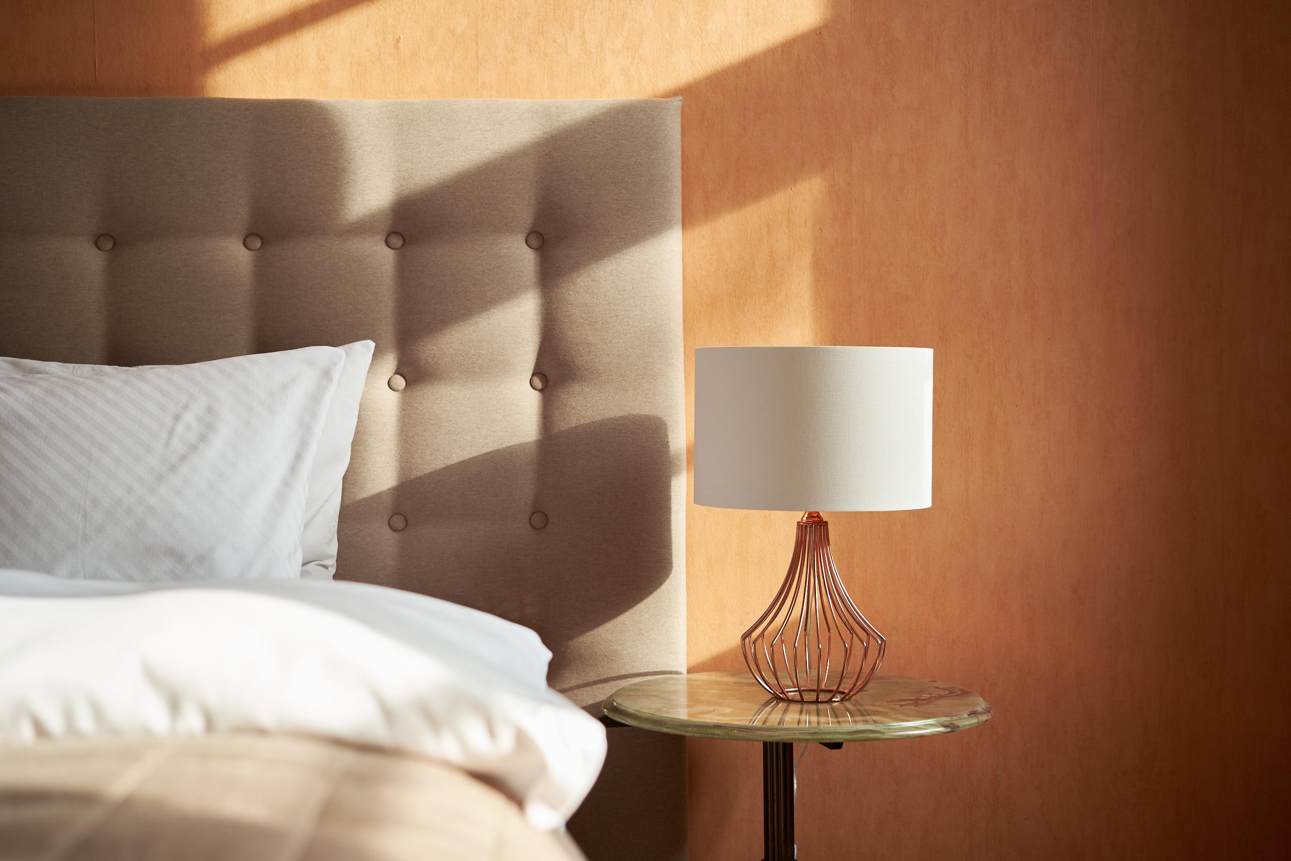 Apartment: Kopfteil vor warmer orangefarbener Wand