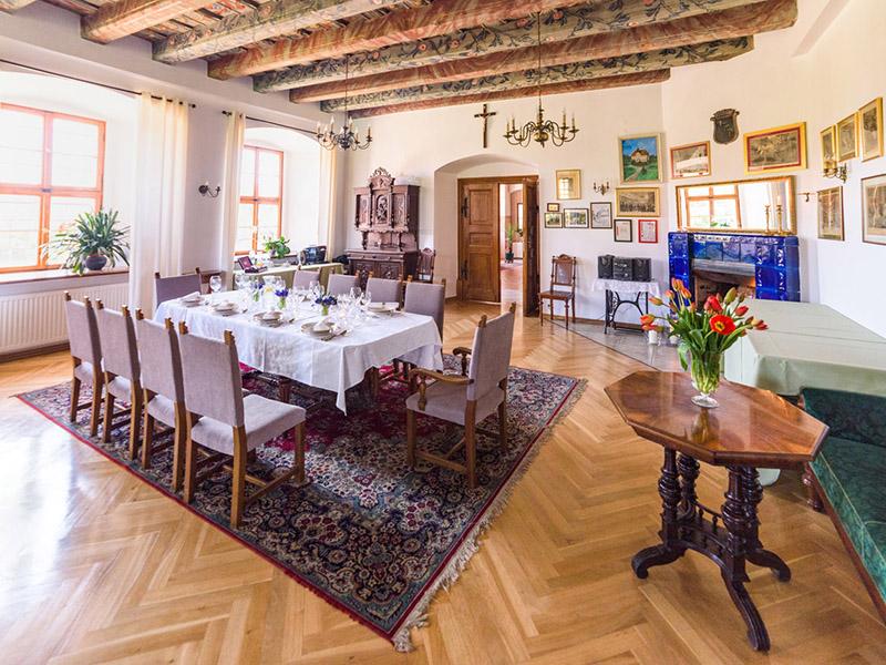 Dining hall with a laid table, rug and timber ceiling