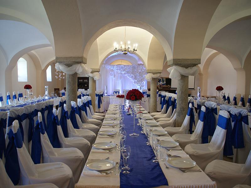 Gewölbter Hochzeitssaal mit dunkelblauer Stuhldekoration