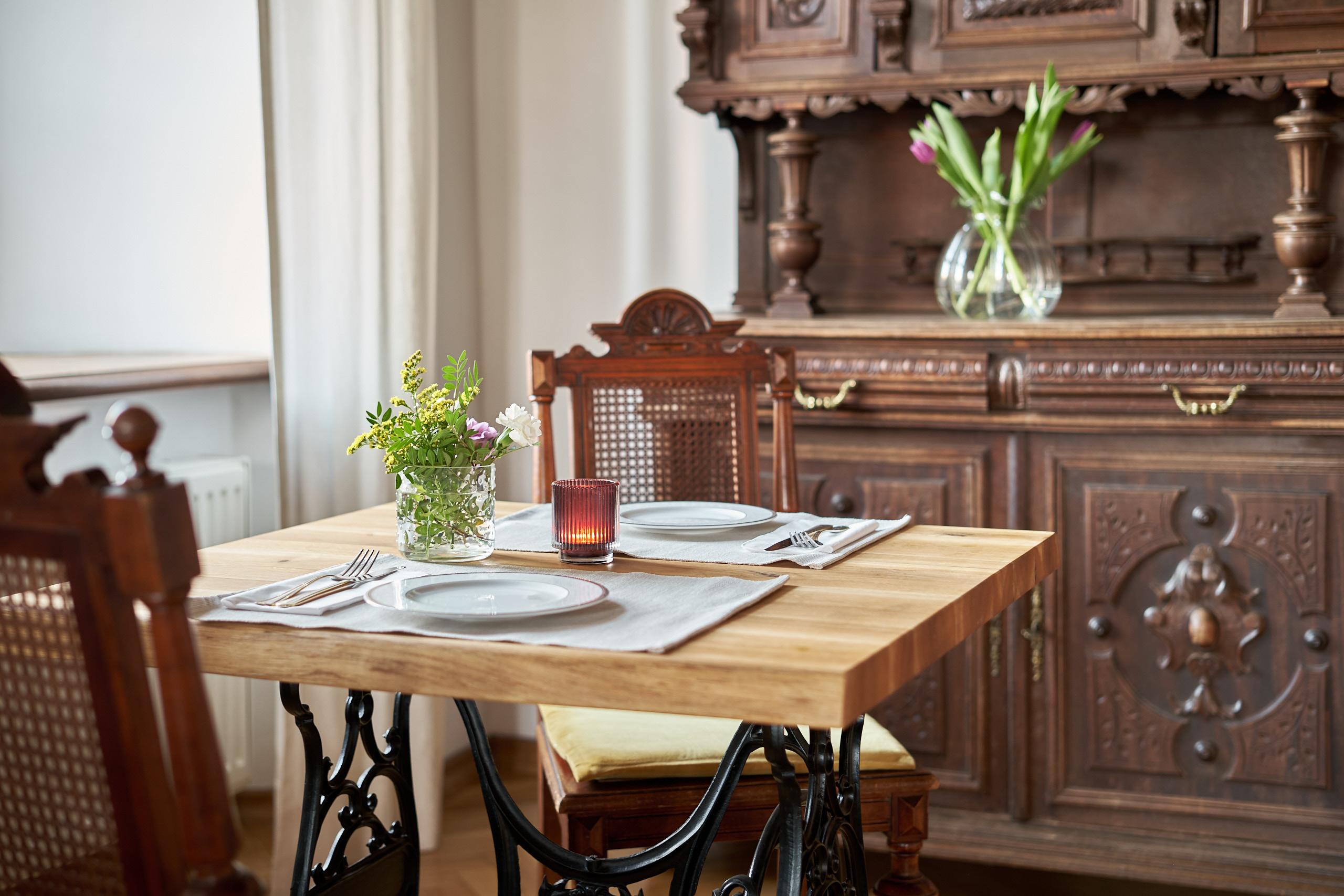 A table set for a meal beside a carved sideboard