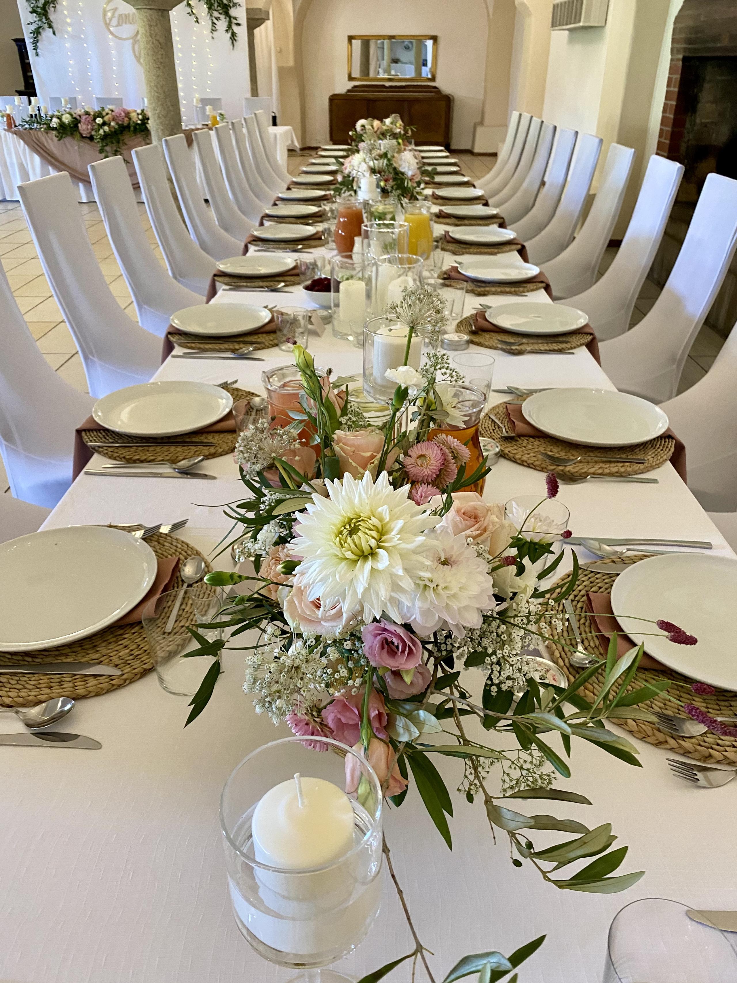 Long wedding table with flowers, candles and place settings