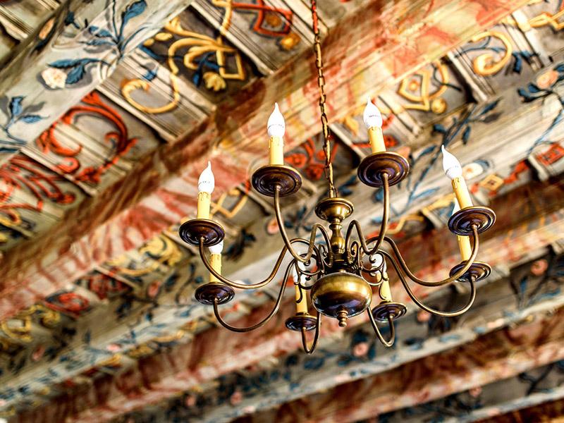 Painted timber ceiling with a brass chandelier