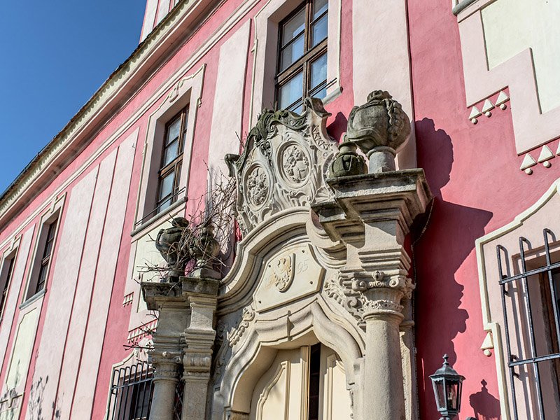Richly carved baroque portal on the pink palace façade